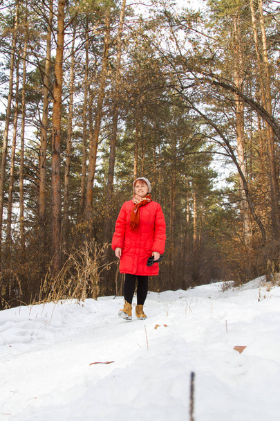 γυναίκα που περπατά σε ένα χιονισμένο δάσος - Φωτογραφία, εικόνα