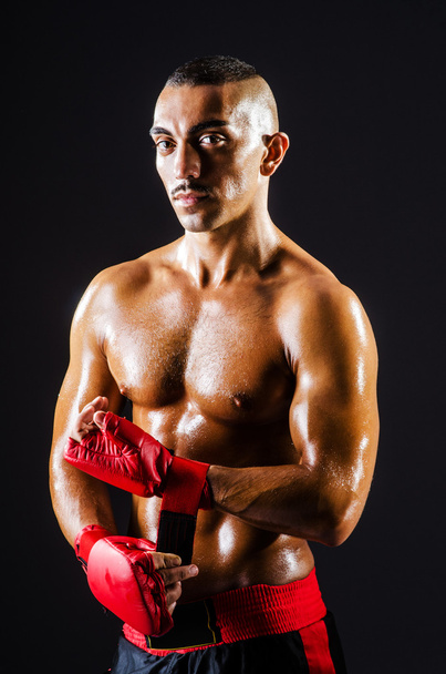 Boxer with red gloves in dark room - Foto, afbeelding