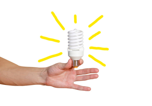 Closeup of man's hand holding energy saving lamp. Bright yellow  - Fotografie, Obrázek