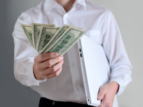 επιχειρηματίας με φορητό υπολογιστή που δίνει χρήματα - Φωτογραφία, εικόνα