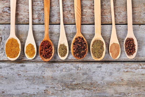 Various Indian colorful spices in wooden spoons.  - Фото, изображение