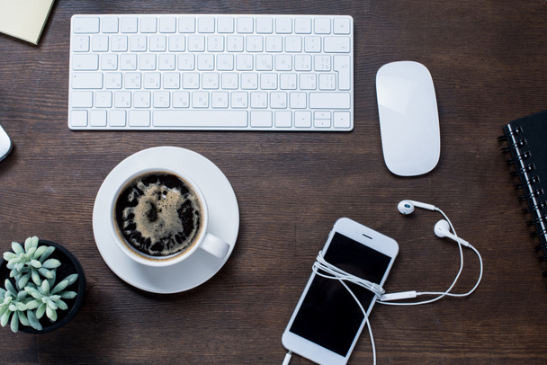 Tazza da caffè e smartphone sulla scrivania
  - Foto, immagini