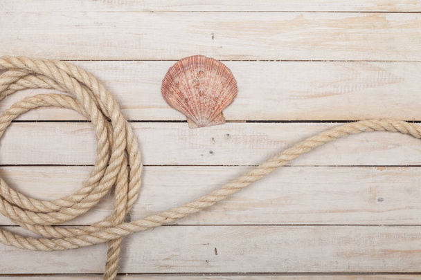 Rope and sea shell on wooden background - Photo, Image