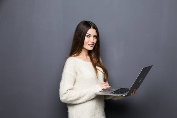 young woman standing and holding laptop. - Valokuva, kuva
