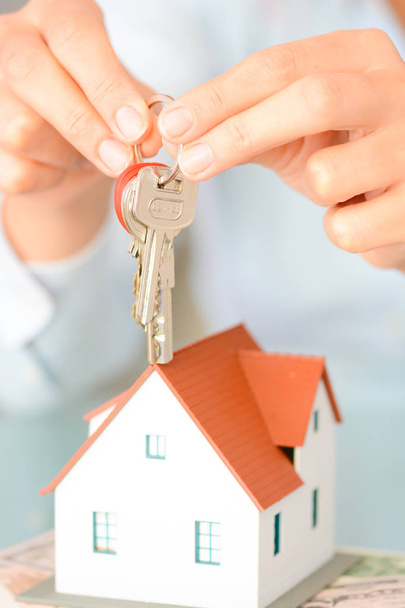 Konieczności zakupu koncepcja domu kobieta rękami trzymając modelu Dom i klucze - Zdjęcie, obraz
