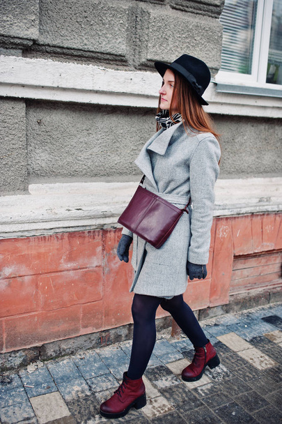 Young model girl in a gray coat and black hat with leather handb - Foto, afbeelding
