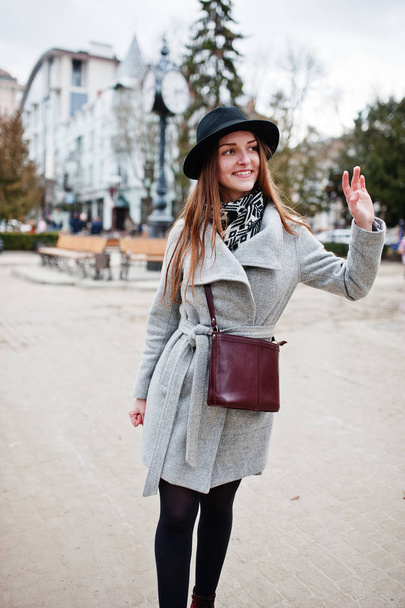 Young model tourist girl in a gray coat and black hat with leath - Foto, Imagem