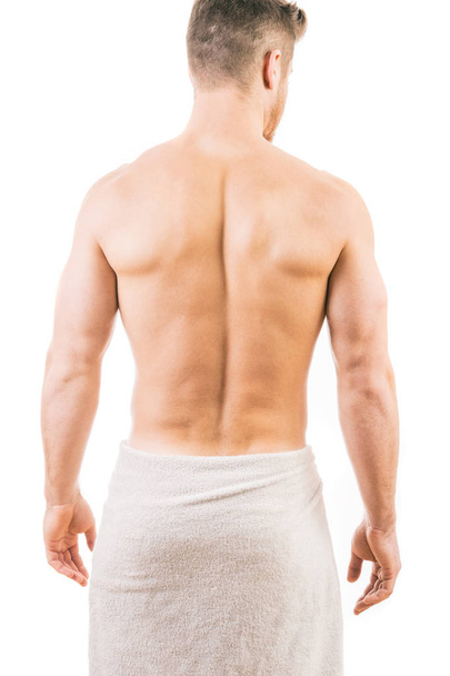 Back view of a muscular young man wearing a towel - Fotoğraf, Görsel