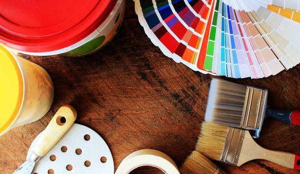 varias herramientas de pintura y paleta de colores sobre fondo de madera
 - Foto, imagen