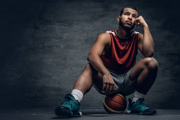 Basketballspieler sitzt auf einem Ball - Foto, Bild