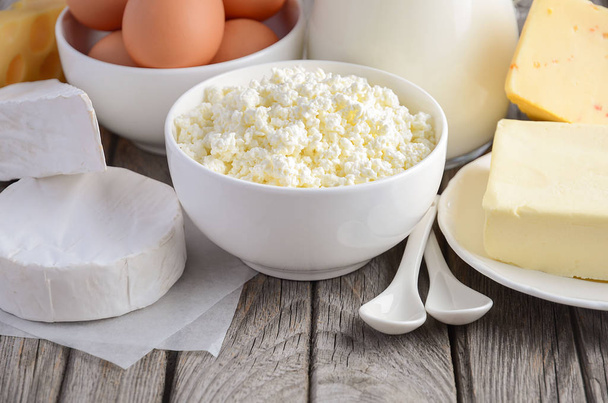 Productos lácteos frescos. Leche, queso, brie, Camembert, mantequilla, yogur, requesón y huevos sobre mesa de madera
. - Foto, imagen