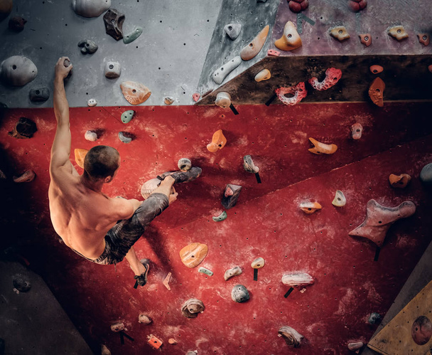 Sportlicher Mann klettert Wand - Foto, Bild