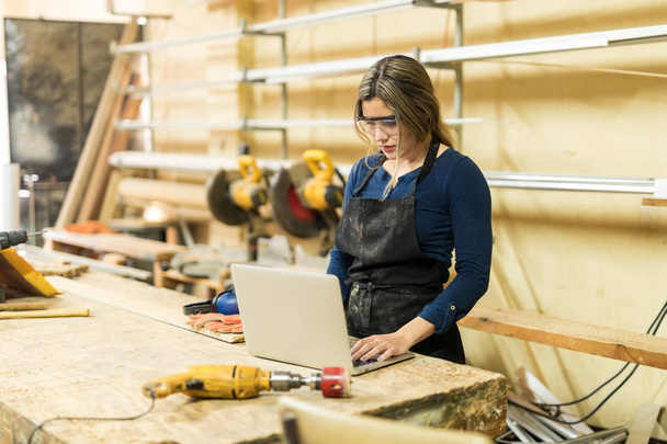 female carpenter using computer - Foto, afbeelding