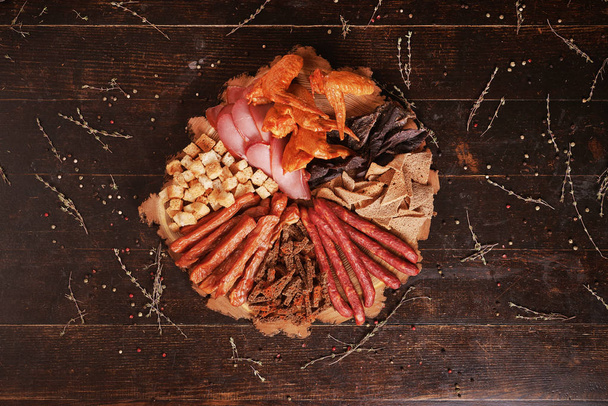Bierteller mit Räucherfleisch, Würstchen, Crackern. Ansicht von oben - Foto, Bild