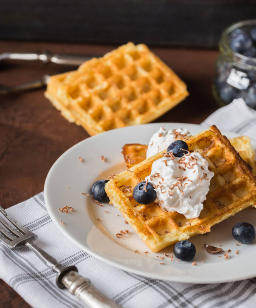 Belgian waffles on white plate, napkin and rustic background. - Foto, afbeelding