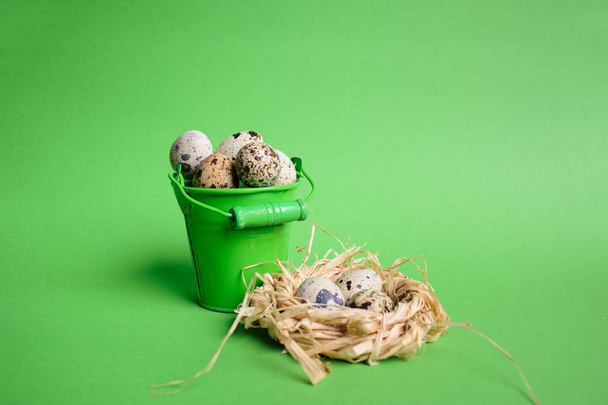 Small decorative buckets filled quail eggs on the green backgrou - Foto, Imagen