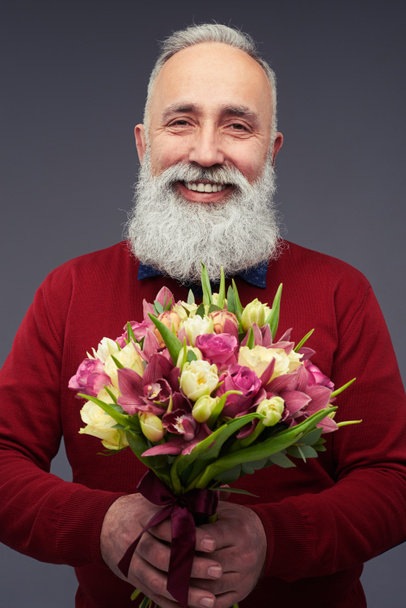 Middle-aged mature man with a bouquet of tulips - Photo, Image