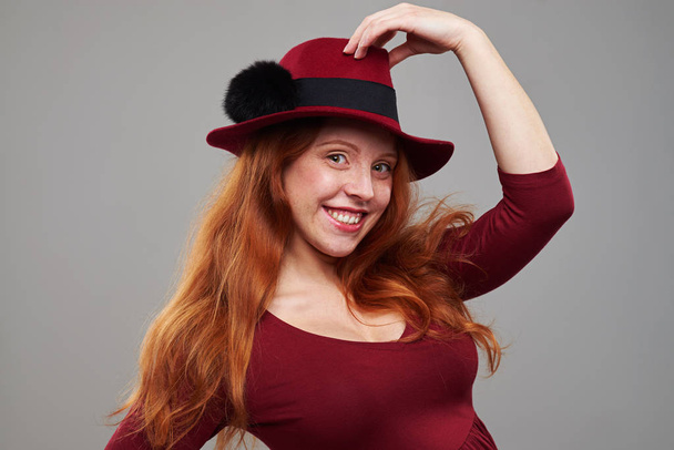 Lovely redhead woman in a cute hat in the studio - Photo, Image