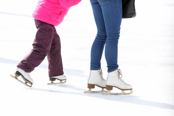 child and adult skates at the ice rink - Фото, изображение