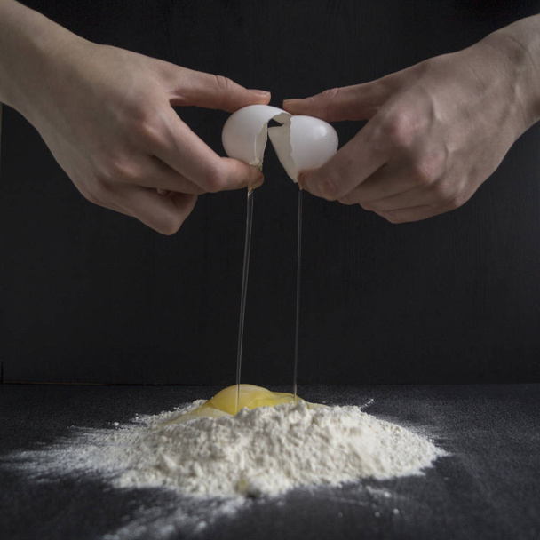 Kobieta ręce break jajko do mąki do ciasta - Zdjęcie, obraz