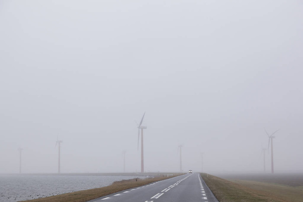 turbinas eólicas em campo nebuloso perto de Almere, nas terras baixas
 - Foto, Imagem