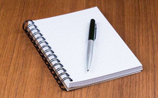 Pen and notebook on a wooden office desk.  - Foto, Imagen