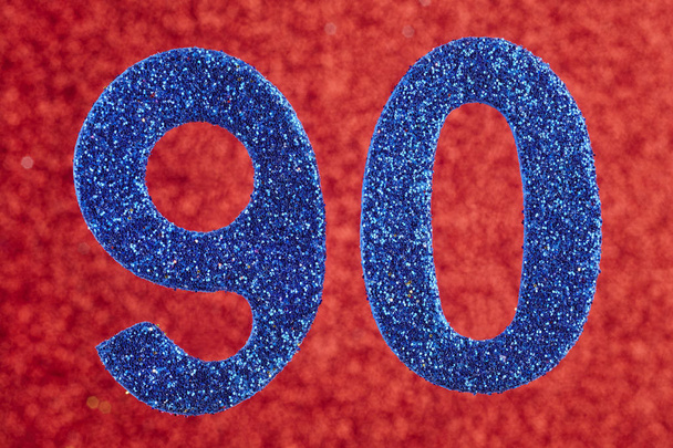 Αριθμός ενενήντα μπλε χρώμα πάνω σε κόκκινο φόντο. Επέτειος.  - Φωτογραφία, εικόνα