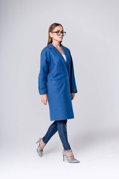 Fashion studio photo of young stylish woman. Blue coat. Catalogue clothes. Lookbook - Zdjęcie, obraz