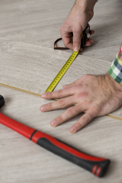 Man installing new laminated wooden floor - Fotó, kép