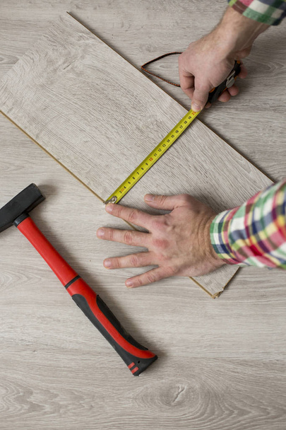 Man laying laminate flooring in construction concept - Foto, afbeelding