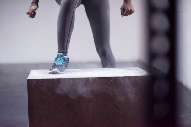 black woman is performing box jumps at gym - Fotó, kép