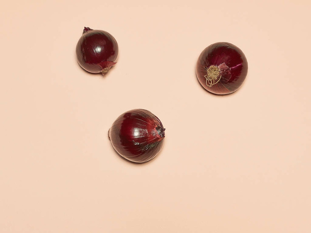 Red onion on a pink background - Fotoğraf, Görsel