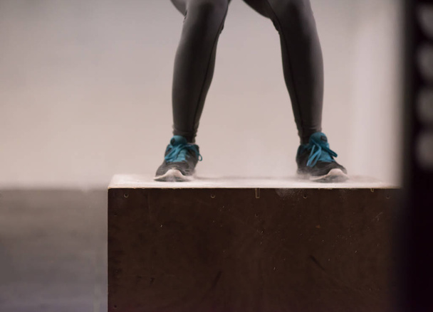 black woman is performing box jumps at gym - Foto, afbeelding