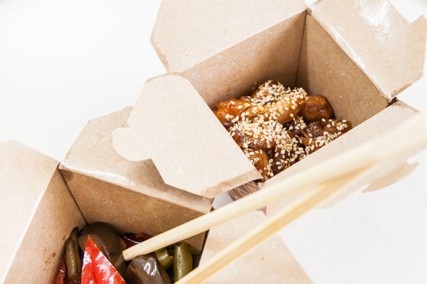 Caixa de entrega com comida chinesa - frango em esmalte doce e azedo com gergelim
 - Foto, Imagem