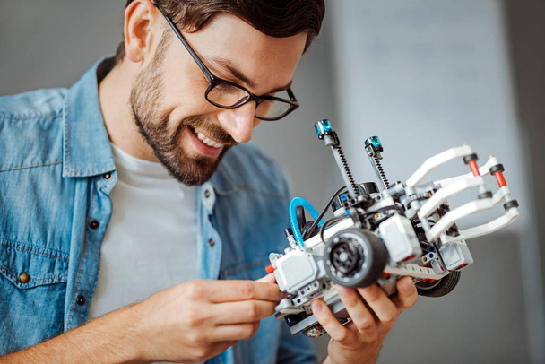 Smiling professional engineer holding robot - Foto, Imagem