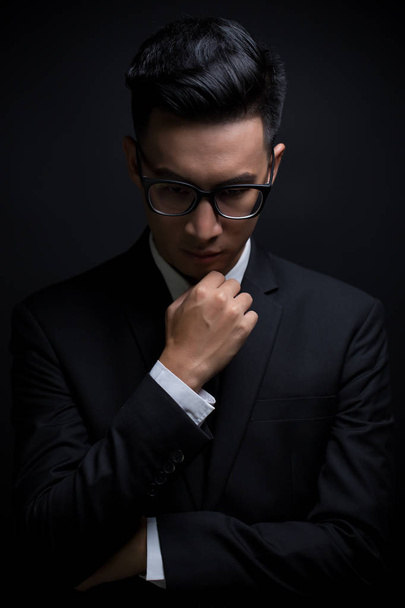 Empresario en traje negro sobre fondo negro aislado
 - Foto, Imagen