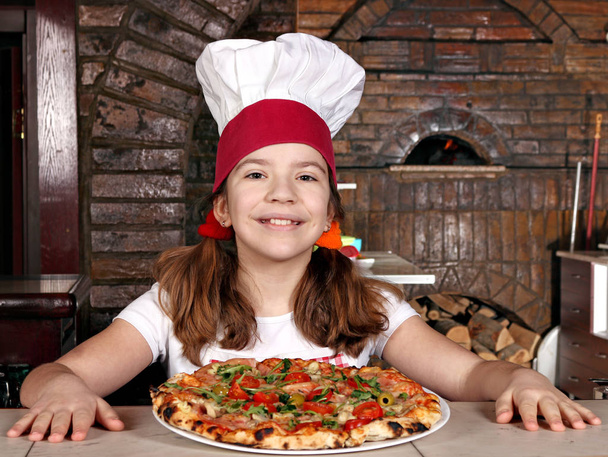 happy little girl cook with pizza in pizzeria - Photo, Image