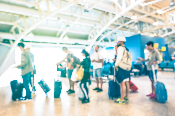 紺碧の太陽フィルター飛行機旅行 - スーツケース荷物バックパックで乗客に旅行放浪癖の概念 - の国際空港のターミナルのゲートでキューで待機してぼやけて多重人 - 写真・画像