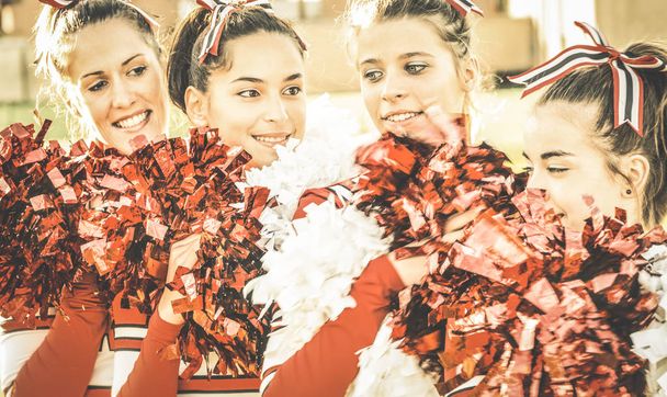 Cheerleader-Gruppe bei der Hochschulsport-Event-Show - Konzept der Einheit und des Mannschaftssports mit aktiven Mädchen - Training an der Hochschule mit jungen weiblichen Teenagern - warmer, ungesättigter Retro-Filter - Foto, Bild