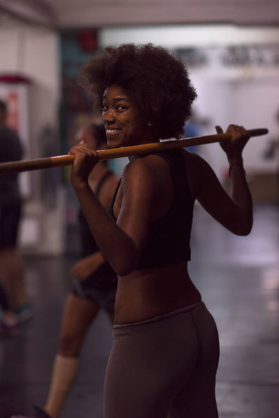 black woman lifting empty bar - Foto, Imagen