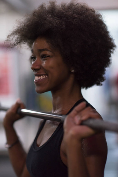 black woman lifting empty bar - Foto, Bild