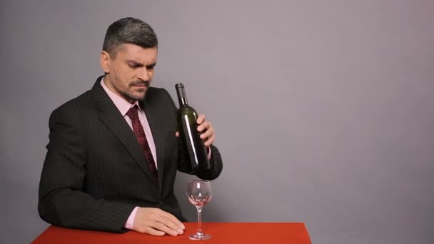 Disappointed man in black suit tasting cheap red wine, displeased winemaker - Кадри, відео
