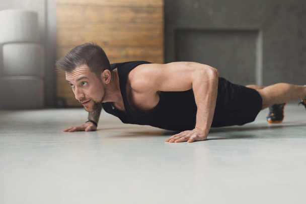 Jonge man fitnesstraining, push-ups of plank - Foto, afbeelding