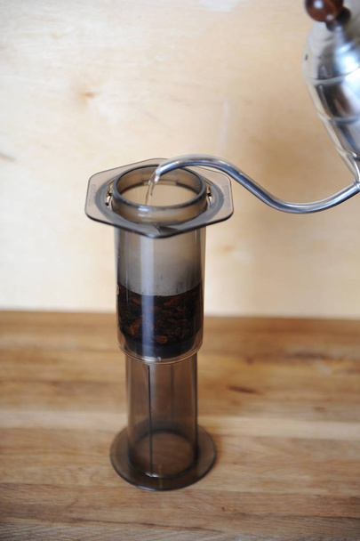 Objekty pro alternativní přípravy kávy na dřevěné pozadí... speciální kávu. Proud vody nalévá z odkapávací maker - Fotografie, Obrázek