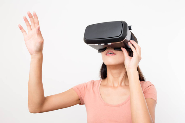 Mulher olhando através do dispositivo VR e mão para cima
 - Foto, Imagem