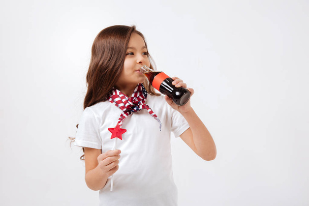 Delighted little girl drinking in the studio - Photo, Image