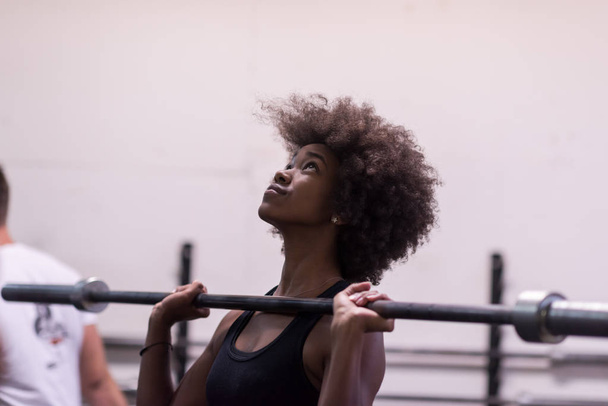 black woman lifting empty bar - Foto, afbeelding