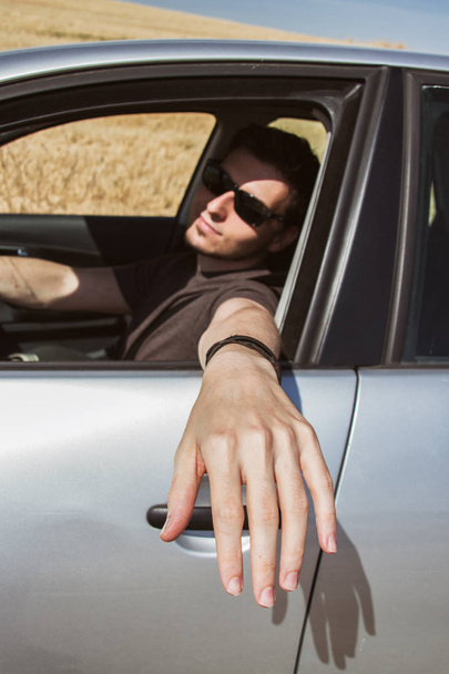 Young man driving a car in summer  - Valokuva, kuva