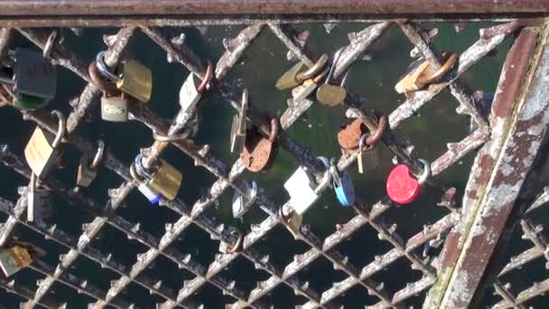 εραστές κλειδώματα σε μεταλλικό φράχτη γέφυρα - Πλάνα, βίντεο