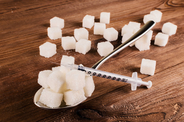 Diabetes. A lot of sugar cubes in spoon and injector - Photo, Image